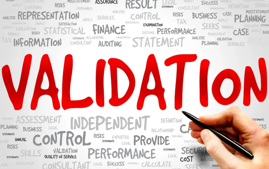 Hand holding a pen with the word validation highlighted among related terms.